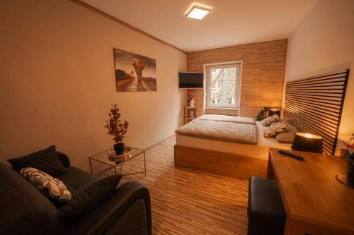 a bedroom with a bed and a couch and a window at Fewos Deutschherrenstraße in Trier