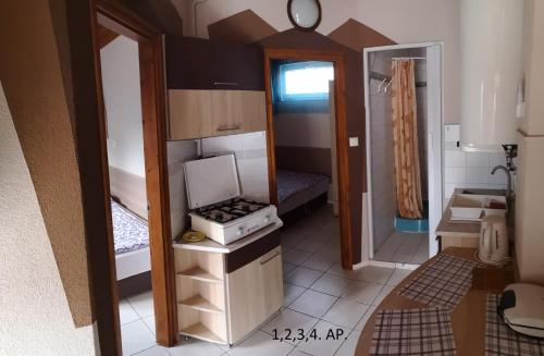 a small room with a kitchen with a stove in it at CSABA-EMILKA-SPA Apartmanok in Hajdúszoboszló