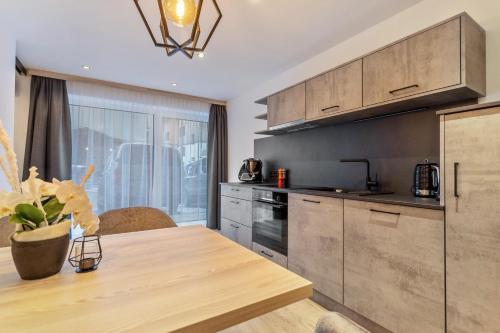 a kitchen with a wooden table and a dining room at Grauzone Grossarl App Nr 1 Cozy in Grossarl