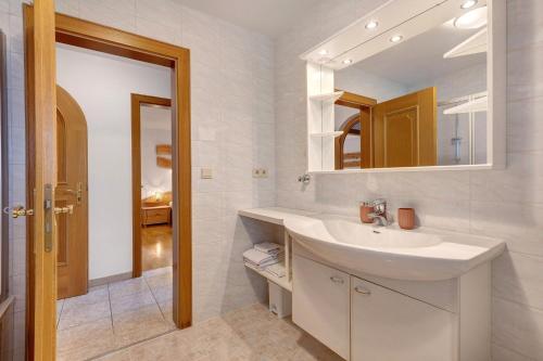 a white bathroom with a sink and a mirror at Wohnung Schlern Heigler Hof in Collepietra
