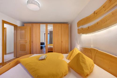 a bedroom with a bed with yellow sheets at Wohnung Schlern Heigler Hof in Collepietra