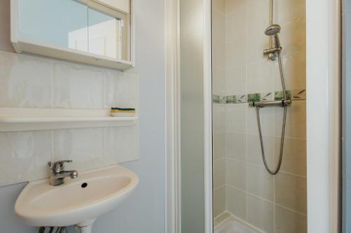 a bathroom with a sink and a shower at Gite Les Dauphins à Matignon in Matignon