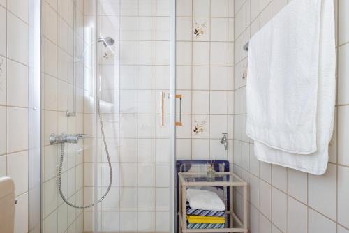 a white tiled bathroom with a shower and towels at Fewo Kessler Schwarzwaldstüble in Häusern