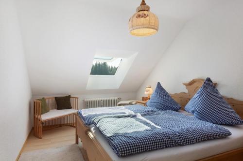 a bedroom with a bed with blue and white pillows at Fewo Kessler Schwarzwaldstüble in Häusern