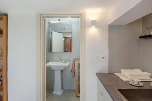 a white bathroom with a sink and a mirror at Livadi House Amorgos in Aegiali