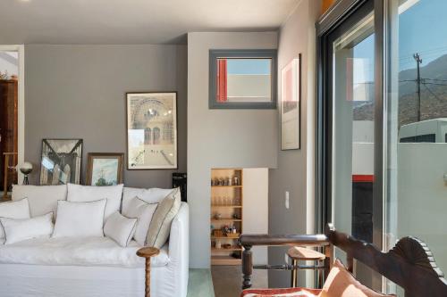 a living room with a white couch and a table at Livadi House Amorgos in Aegiali