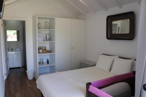 a bedroom with a white bed and a mirror at Casa do Mestre Inteira in Vila de Punhe