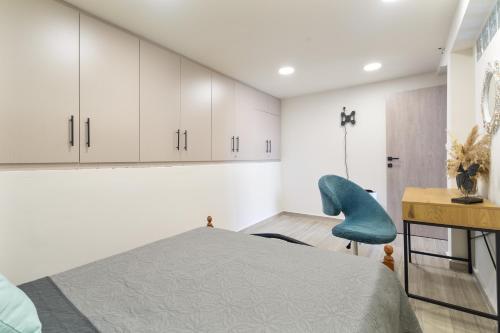 a bedroom with a bed and a blue chair at Villa Andreas in Athani