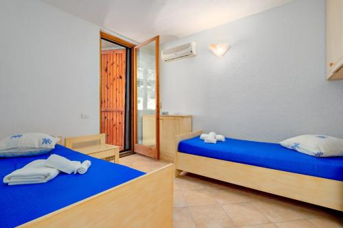 a bedroom with two beds with towels on them at Casa Ioana in Cugnana Verde
