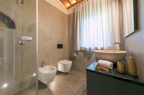 a bathroom with a sink and a glass shower at Le Sughere in Riparbella
