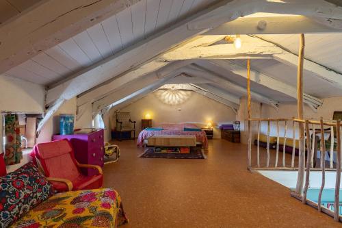 a large room with two beds and chairs in it at La Casita in Beauvène