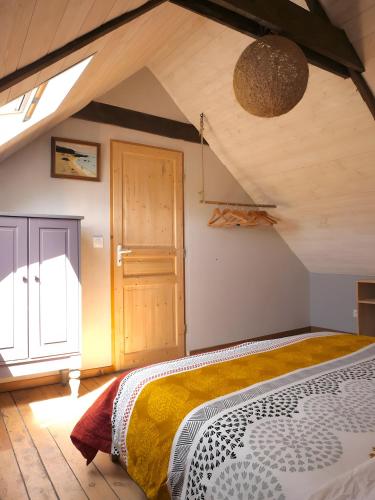 a bedroom with a large bed in a attic at Gîte Le Penn-ty in Rosporden