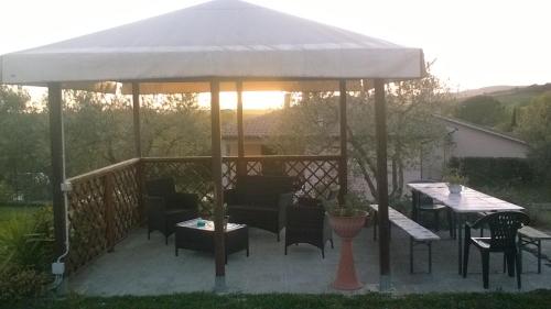 a gazebo with chairs and tables on a patio at Residence Ai Campi Da Golf Saturnia in Saturnia