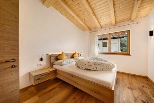 a bedroom with a bed in a room with a window at Unterötzbauerhof - Fewo Rosenblick in Tirolo
