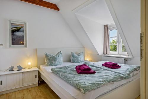 a bedroom with a bed and two windows at Fewo Silbermöwe in Pellworm