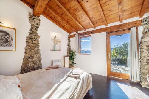 a bedroom with a bed and a stone wall at Le Grand Mas de Can Noy in Montferrer
