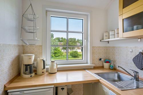 a kitchen with a counter top with a window at Fewo Silbermöwe in Pellworm