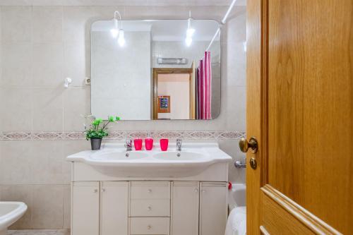 a bathroom with a white sink and a mirror at Setúbal Dreams in Setúbal