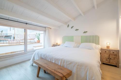 a bedroom with a large bed and a window at Casa La Roca in Pollença