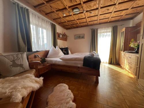 a bedroom with a bed and a couch and a window at Oberbründlingchalet in Taxenbach