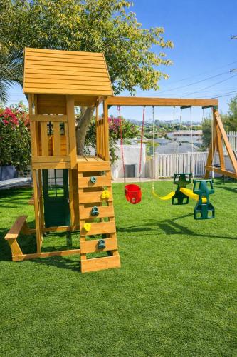 a wooden play set with a swing and a playground at CasaViva Breeze - 2BR with Sunset Views, Firepit & Backyard - Walk to Fun & Eats in North Park & Hillcrest, 5 Min to Gaslamp in San Diego