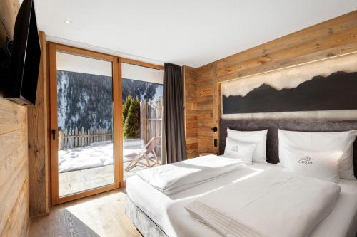 a bedroom with two beds and a large window at Chalet-Suite Wald in Selva dei Molini