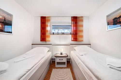 two beds in a small room with a window at Wellness Ferienwohnung Strandperle in Cuxhaven
