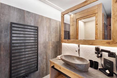 a bathroom with a stone sink and a mirror at Chalet-Suite Wald in Selva dei Molini