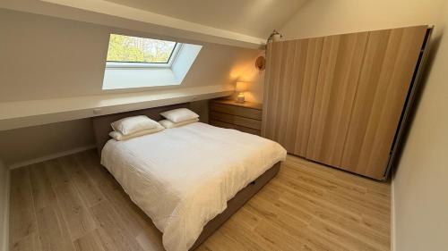 a small bedroom with a bed and a window at Deluxe home garden and pool optional pm in Kortenberg
