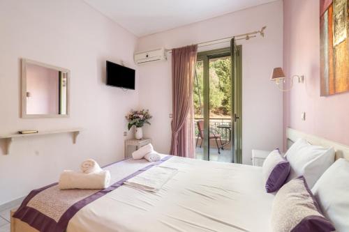 a bedroom with a large white bed with a window at Nontas Home 25 in Kalamitsi