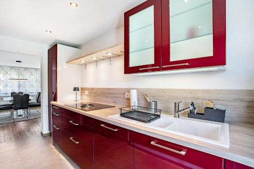 a kitchen with red cabinets and a sink at Zum alten Wald in Zell am Harmersbach