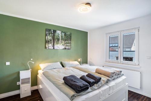 a bedroom with a large bed with a green wall at Zum alten Wald in Zell am Harmersbach