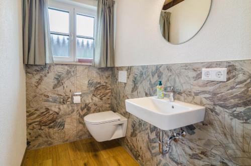 a bathroom with a sink and a toilet and a mirror at Landluft Ferien - Wohnung Abendrot in Heiligenberg
