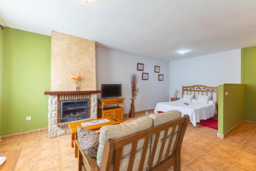 a living room with a bed and a fireplace at La Casa de Dafne Acebo in Santo Tomé del Puerto