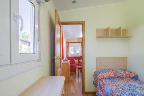 a bedroom with a bed and a table and a window at Bungalow C in Pontevedra