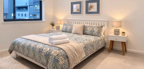 a bedroom with a bed with two night stands and a window at Private room and bathroom in shared flat with parking in Glasgow
