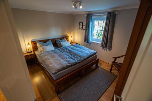 ein Schlafzimmer mit einem Bett mit blauer Bettwäsche und einem Fenster in der Unterkunft Jachthuus in Brilon