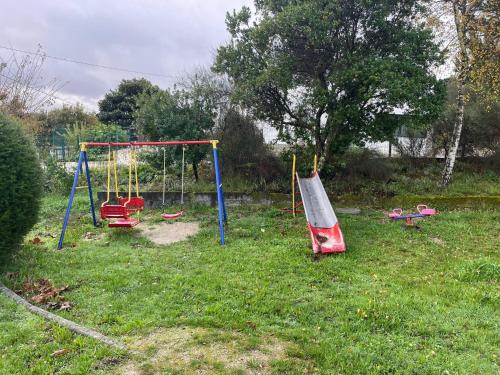 a yard with two swings in the grass at Jorge Galinheiro Alojamento Local in Mamouros