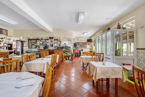 a dining room with tables and chairs and a restaurant at Jorge Galinheiro Alojamento Local in Mamouros