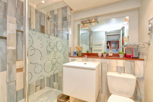 a bathroom with a toilet and a sink at Appartement face mer et Piscine in Le Croisic