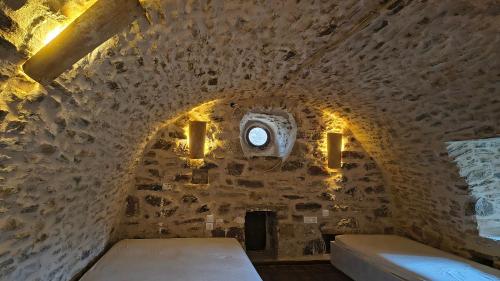 a room with a bed in a stone wall at Pyrgos Mitsakou 2 in Vathia