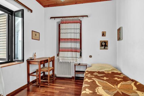 a bedroom with a bed and a desk and a window at Barba Panais' House in Vonitsa