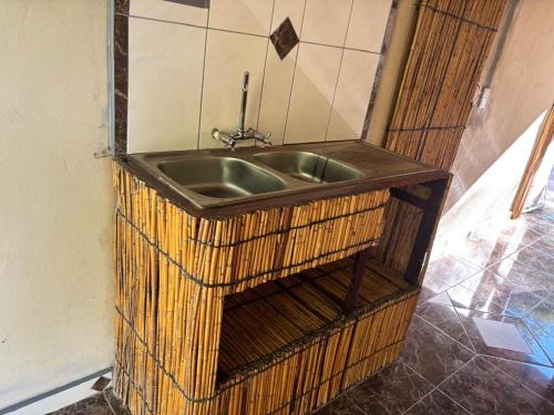 a metal sink in a wicker rack in a bathroom at Emms Cubango Ecological Camp in Divundu