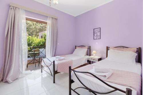a bedroom with two beds and a balcony at Villa prolithia 1 in Vlikhón