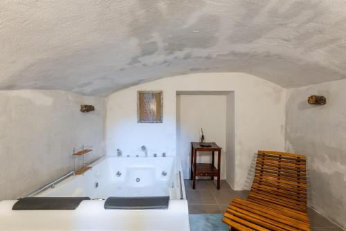 a white bathroom with a tub and a chair at Antiche Dimore Del Vescovado in Siena