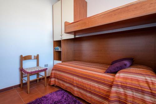 a bedroom with a bunk bed with a wooden headboard at Casa Sara Lu Bagnu in Castelsardo