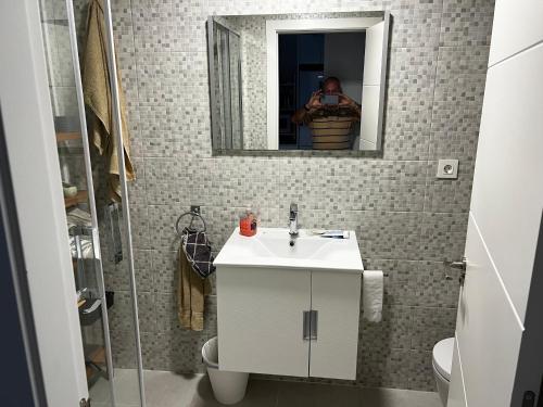a man taking a picture of a bathroom with a sink at Rodalia in El Verger