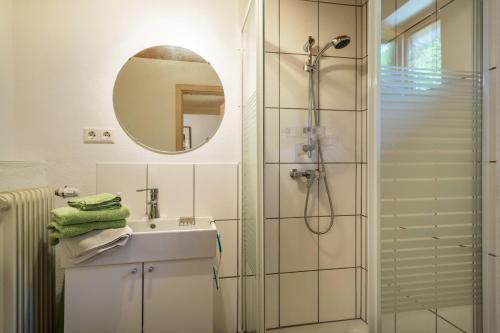 a bathroom with a shower and a sink and a mirror at Tobelbach in Weiler-Simmerberg