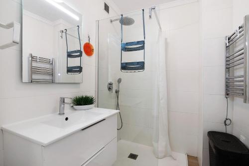 a white bathroom with a sink and a shower at Abertura Mar Zen in Quarteira
