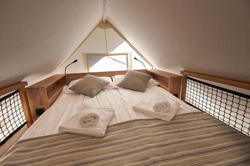 a large bed in a room with towels on it at Safarizelt in Großenbrode